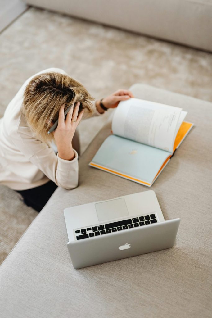 Overhead view of a student studying with a laptop and books indoors.