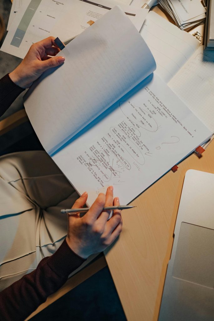 Top view of a student studying with notes on a desk, emphasizing education and focus.